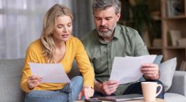 Photo d'un couple homme/femme en train de lire des documents sur le plafond de leur livret a