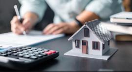 Photos de mains au-dessus d'un contrat et à côté d'une maquette de maison et d'une calculatrice illustrant l achat en vefa