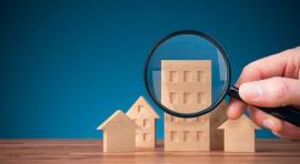 Photo d'une maquette de maison avec une loupe posée devant pour illustrer l investissement en lmnp