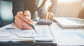 homme penche sur un bureau calculant le montant de ses impots 