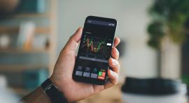 main-tenant-telephone-portable-regardant-graphiques-pour-tout-savoir-sur-la-cryptomonnaie
