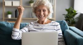 Femme-senior-devant-un-ordinateur-joyeuse-grace-a-meilleur-placement-pour-senior
