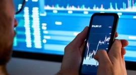 homme avec Smartphone affichant un graphique de bourse à l'écran pour investir 1000 euros