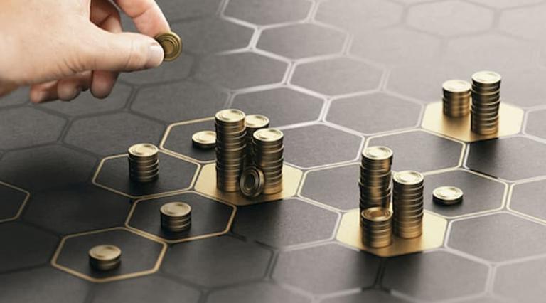 Main qui pose des pièces de monnaie en tas