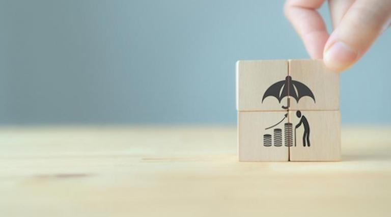 Des dés de puzzle qui empilés montre un homme et son argent sous un parapluie