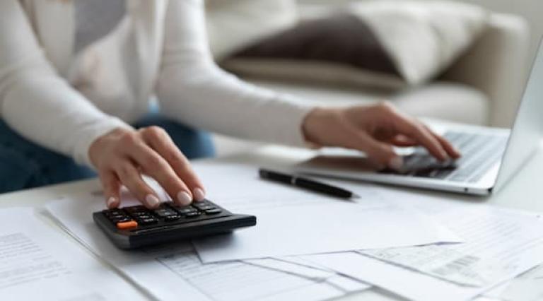 Mains posees sur une calculatrice en rapport avec les PER et un clavier d ordinateur