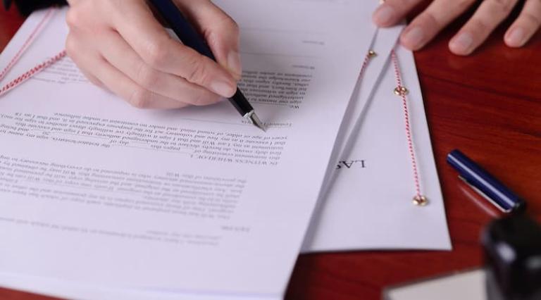 Personne en train de lire et annoter un document de renoncement a une sucession