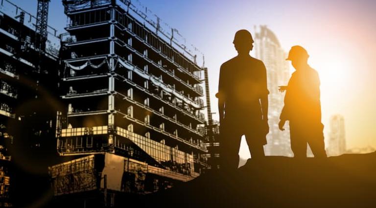 Photo de 2 personnes devant un chantier de construction de scpi