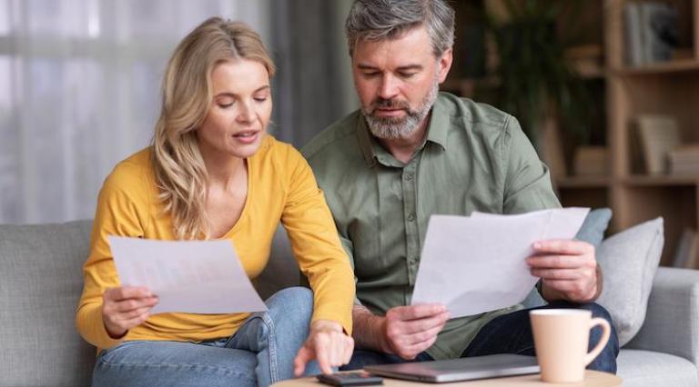 Photo d'un couple homme/femme en train de lire des documents sur le plafond de leur livret a