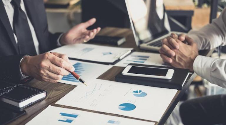Photo de personnes autour de graphiques pour un rachat d assurance vie