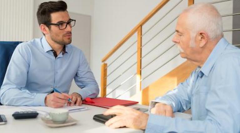 Photo d'un senior avec un conseiller pour discuter transmission de parts de scpi