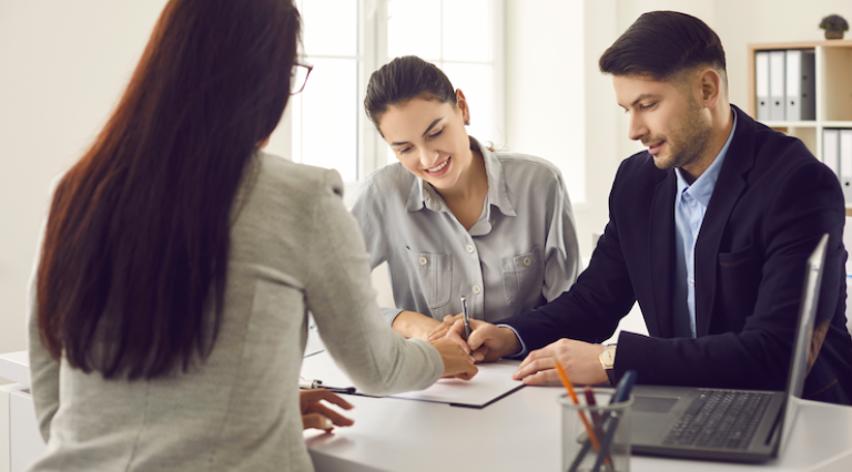Couple homme/femme avec une conseillère en train de signer un contrat assurance vie