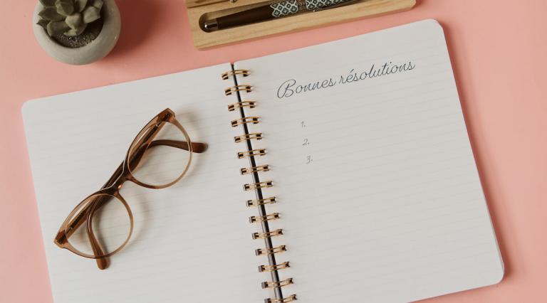 Photo d'un cahier avec inscrit "bonnes résolutions" illustrant les bonnes pratiques d epargne