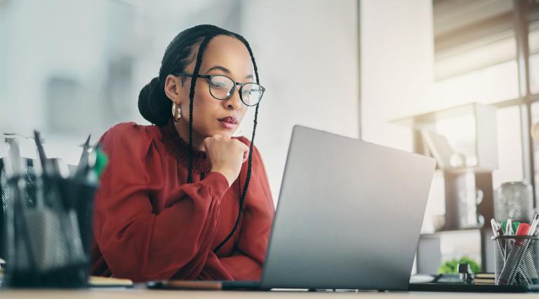 femme-regardant-documents-et-reflechissant-dans-quoi-investir-cette-annee-ampoule-allumee-premier-plan