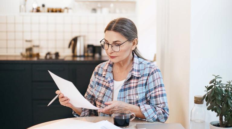 femme-dans-cuisine-regardant-papiers-sur-optimisation-fiscale-pea-retraite-ou-cloture-anticipee