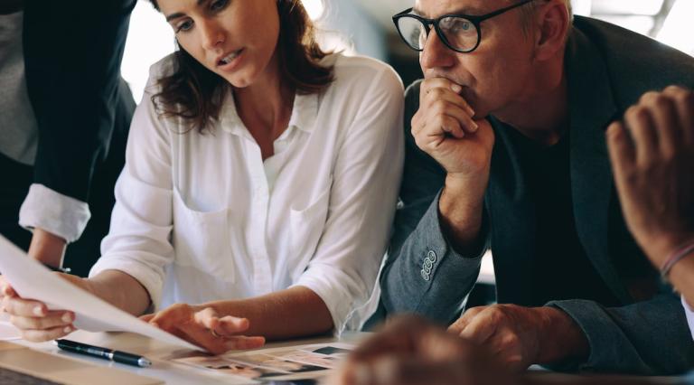 homme-et-femme-autour-table-reunion-reflechissant-comment-gerer-epargne-pendant-periodes-incertitude-economique
