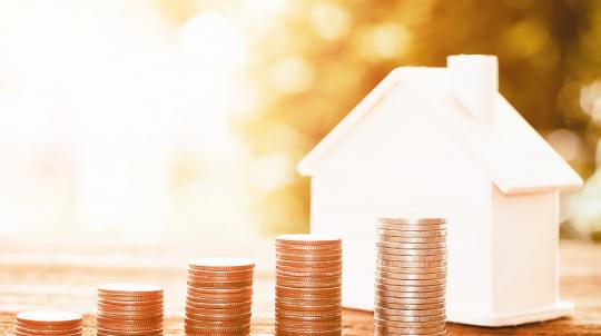 Piles de pièces et petite maison pour illustrer la taxe d'habitation 2020