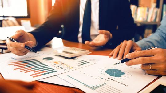 Personnes analysant des documents pour illustrer le choix de placements pour l'année 2021